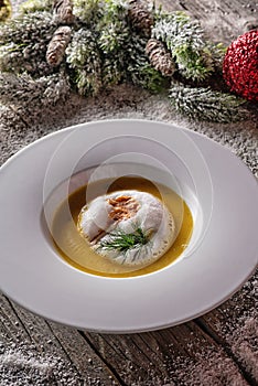 Chrismas fish soup in white plate with christmas decorations, modern gastronomy