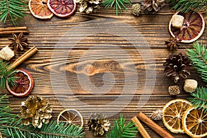 Chrismas holiday brown background. Dried sicilian oranges with cinnamon sticks, anise and golden cones. Copy space