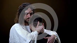 Christ hugging depressed parishioner dark background, God kindness, protection