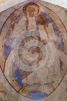 Christ pantocrator rises his right hand, an ancient romanesque m