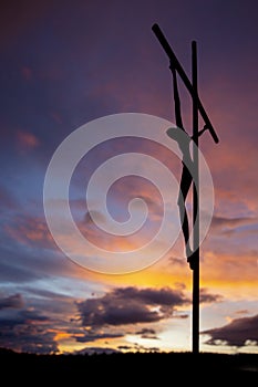 Christ`s body on the cross at dawn. backlight. vertical image. selective focus. copy space