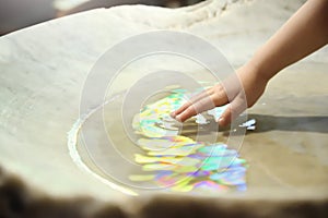 Christening celebration. Baptismal pile and a hand with sacred water in a church. Empty copy space