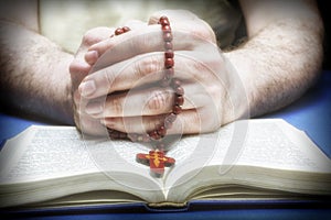 Christian believer praying to God with rosary