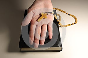 Christian Bible, Hands and Wooden Cross on a White Background