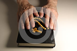 Christian Bible, Hands and Wooden Cross on a White Background