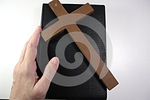 Christian Bible, Hands and Wooden Cross on a White Background