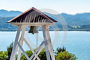 A christian church bell with the sea in the background