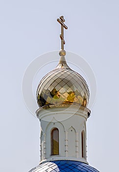 christian church with a dome and a cross without people against a blue sky