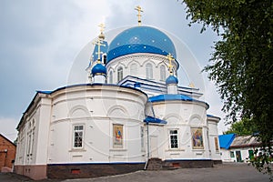 Christian Church of white stone with blue domes with stars and gold crosses.