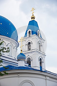 Christian Church of white stone with blue domes with stars and gold crosses.