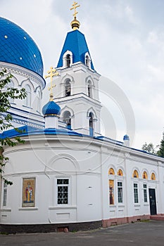 Christian Church of white stone with blue domes with stars and gold crosses.