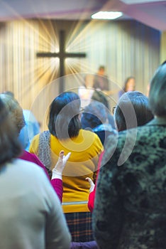 Christian congregation worship God together, with cross with light rays in background