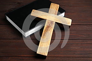 Christian cross and Bible on wooden background. Religion concept