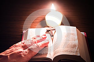 Christian cross .Burning candle and Bible . The psalms . Holy book