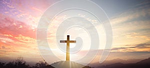 Christian cross concept: Silhouette cross on mountain sunset background