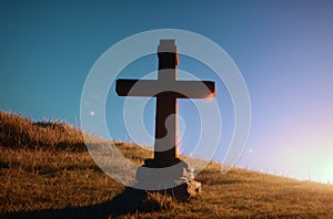 Christian cross in countryside at sunset. Christian cross in nature at sunrise. Generative AI.