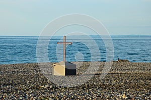 Christian cross crucifix on rocky Black Sea beach seafront Batumi Georgia