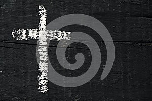 Christian cross on a dark gray wooden surface