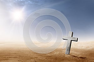 Christian cross on the desert with sun rays