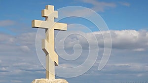 Christian cross on grave stone, peaceful blue sky background, religion, church