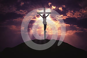 Christian cross on hill at sunrise
