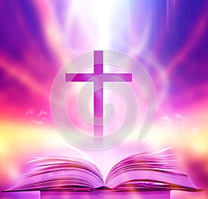 The Christian Cross is illuminated in a book in white and fantasy light, with magic shining as hope, love and freedom in beautiful