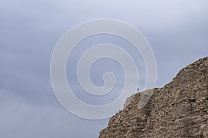 Christian cross on mountain cliff. Religion recluse concept.