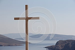 Christian cross over sea landscape