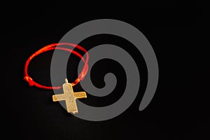 Christian cross on a red rope, on a black background with an empty place. Stock photo cross top