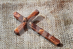 Christian Cross - symbol of the Christian faith, the main attribute of Christians. Wooden cross handmade on fabric background