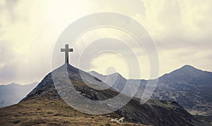 Christian cross on top of the hill with sunrays, crucifixion, re