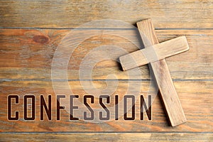 Christian cross and word Confession on wooden background, top view