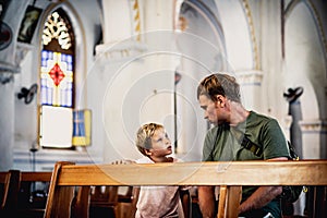 Christian dad tells child Bible story about Jesus holy people, sit in kirk. Faith religious education, modern church