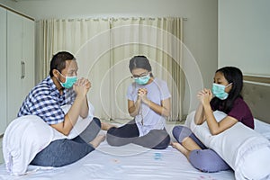 Christian family praying at home together
