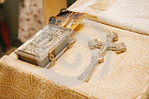 Christian cross, Bible, bottles of oil on a Golden cloth in the Church