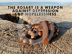 Christian inspirational quote - The rosary is a weapon against depression and hopelessness. With wooden rosary with Jesus Christ.