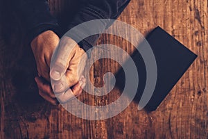 Christian man praying with hands crossed