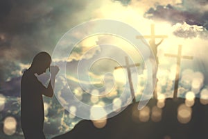 Christian man praying to God with three crucifixes