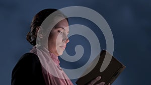 Christian modest woman studies the Bible against the background of thunderclouds