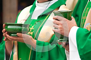 Christian priests holding bowls of wafer and wine photo