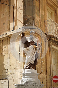 Christian statue as a facade decoration for a building in the historic center of Valletta, Malta