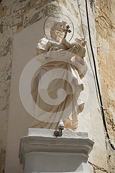 Christian statue as a facade decoration for a building in the historic center of Valletta, Malta