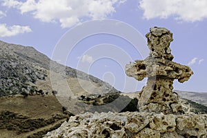 Christian stone cross on a background of cloudy sky and high mountains