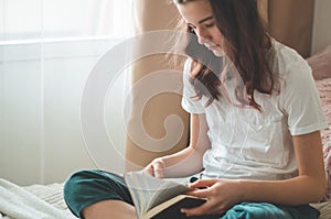 Christian teenage girl holds bible in her hands. Reading bible in a the living room. concept for faith, spirituality and religion