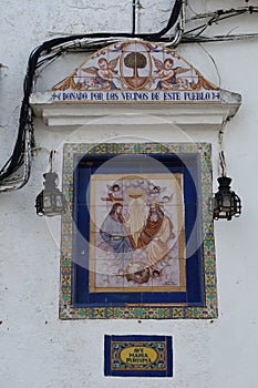 Christian tiles donated by neighbors in a street of the Andalusian magical town of CastaÃÂ±o del Robledo, Huelva, Spain photo