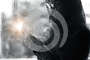 Christian woman with cross in hands praying hope and worship on the raindrop background. Abstract lighting. Eucharist therapy bles