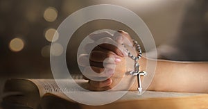 Christian woman hand on holy bible worship to god holding cross rosary