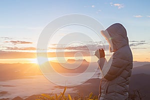 Christian woman hands praying to god on the mountain background with morning sunrise. Woman Pray for god blessing to wishing have