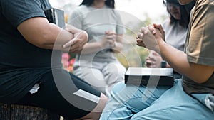 Christian woman held hands with the group, expressing their faith through prayer and devotion to God, uniting in their shared