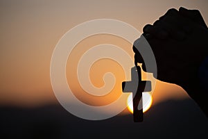 Christian woman praying on holy cross in the morning, teenager woman hand with cross praying,Hands folded in prayer in church